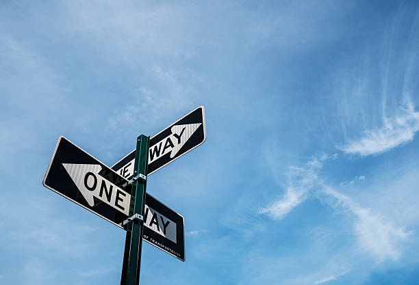 einfache fahrt beschilderung - conflict one way sign road sign stock-fotos und bilder