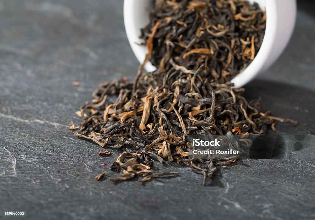 Elite black tea Elite black tea spilled from the container Oolong Tea Stock Photo
