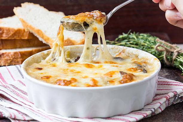 Mushrooms gratin with cream, cheese, French dish julienne stock photo
