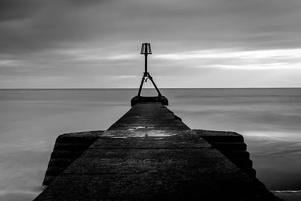 Black and white Long Exposure image of the jetty or walk way at the seaside beach