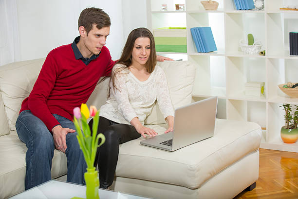 istock Young Couple Using Their Laptop Together At Home 539058625