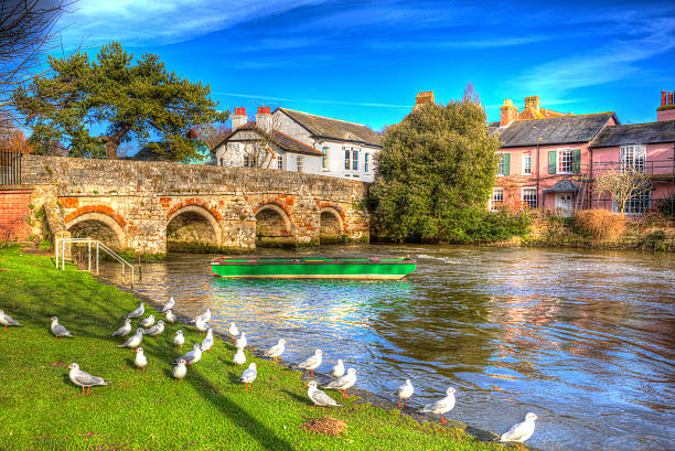River Avon Christchurch Dorset England UK bridge and boat HDR River Avon Christchurch Dorset England UK with bridge and green boat like a painting in vivid bright colourful HDR christchurch england photos stock pictures, royalty-free photos & images