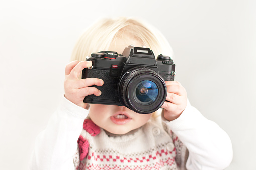 little child holding a camera ready to take a picture