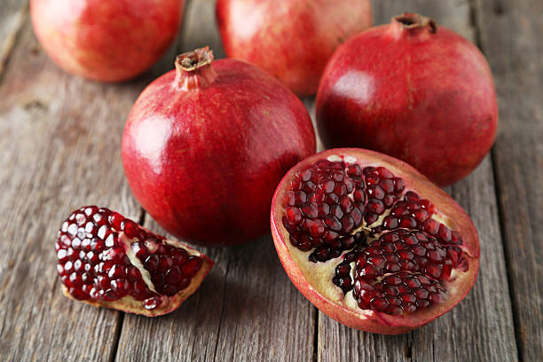 istock Delicious pomegranate fruit on grey wooden background 539080575