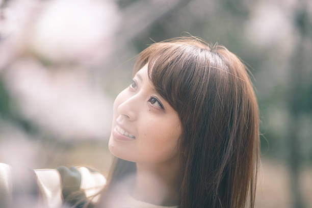 istock Japanese girl looking at cherry blossoms 539088604