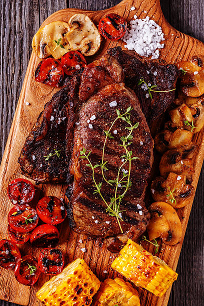 istock Beef steaks with grilled tomatoes, mushrooms and corn. 539089564