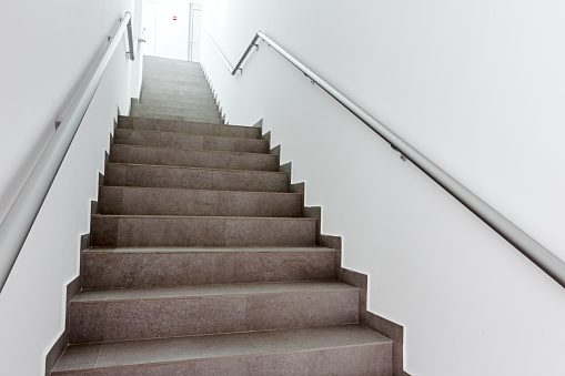Stairway with metallic banister in a new modern building. Every building is required to have emergency stairways as safety measure.
