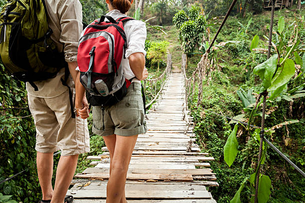 istock Couple with backpack hiking in rainforest jungle 539094279