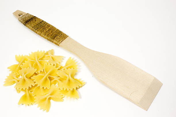 Wooden spoon and pasta on a white background