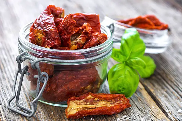 Sun dried tomatoes on wooden background