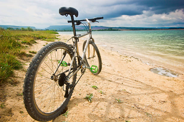 istock bicycle on a bank of blue lake 539106165