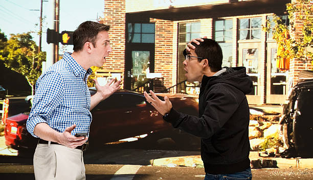 istock Men quarreling in front of car crash 539111562