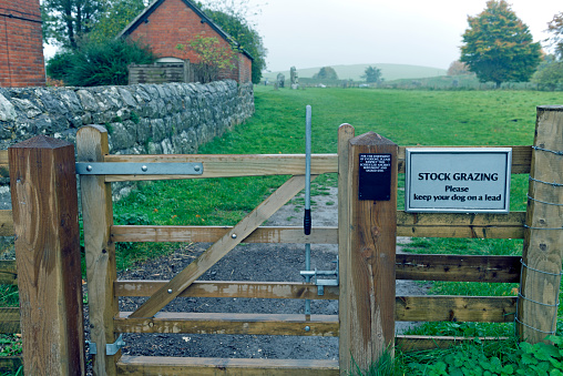 Self-latching gate at entrance to sheep pasture and prehistoric Avebury stone circle in England