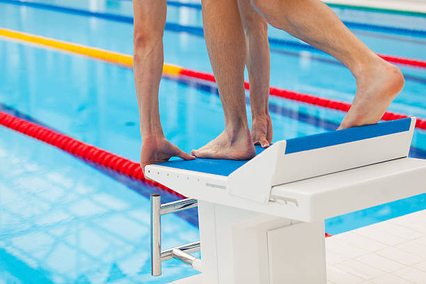 istock Young muscular swimmer in low position on starting block in 539112724