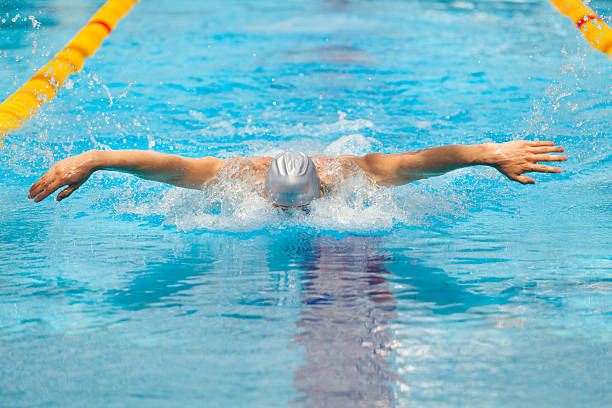 istock dynamic and fit swimmer in cap breathing performing the butterfly 539113118