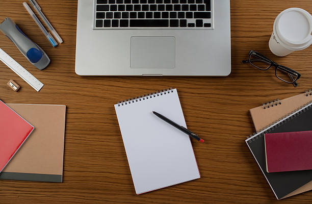 istock blank white page on wooden desk with laptop 539115340