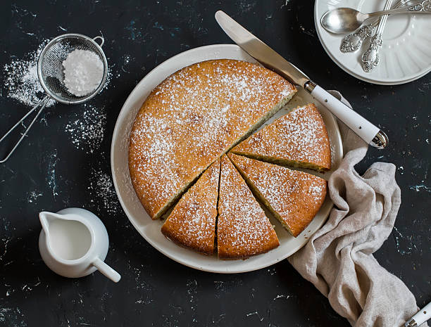 Simple orange cake with olive oil on a dark background. Simple orange cake with olive oil on a dark stone background.  Delicious dessert powdered sugar stock pictures, royalty-free photos & images