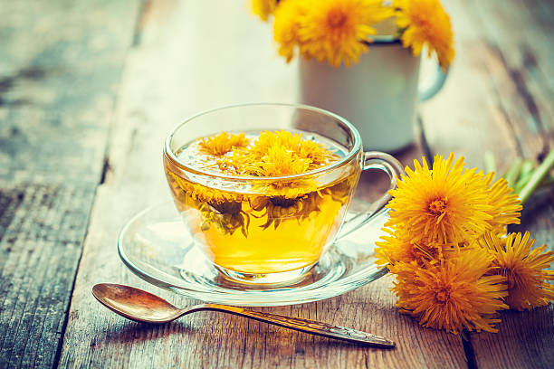 Cup of healthy dandelion tea. Herbal medicine. Retro toned. stock photo