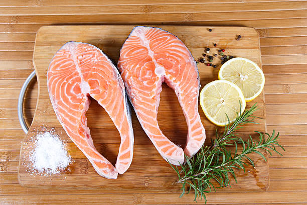istock Raw salmon with lemon on wooden table 539118535