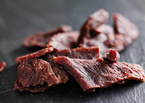 pile of beef jerky shot with selective focus pile of beef jerky shot with selective focus on slate table chewy photos stock pictures, royalty-free photos & images