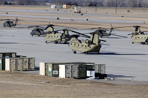 Military helicopter flying above a military base during a mission.