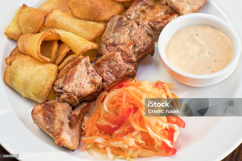 Grilled pork Grilled pork, baked potatoes and vegetable salad 2015 Stock Photo