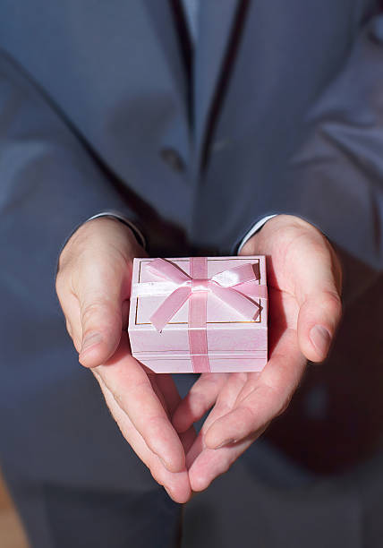 istock Gift box in man's hand with red ribbon 539120529