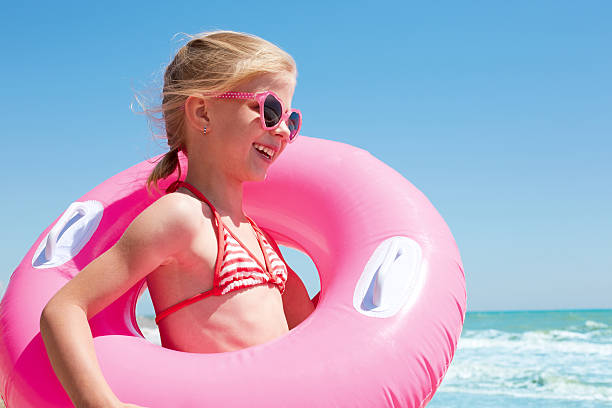 dziewczynka gra z nadmuchiwany pierścień na plaży - inflatable ring obrazy zdjęcia i obrazy z banku zdjęć