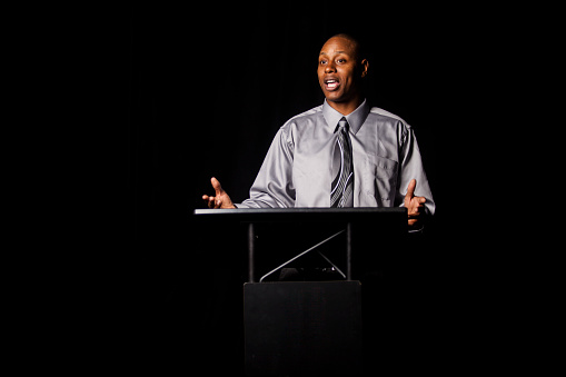 African American man giving a speech at a podium.