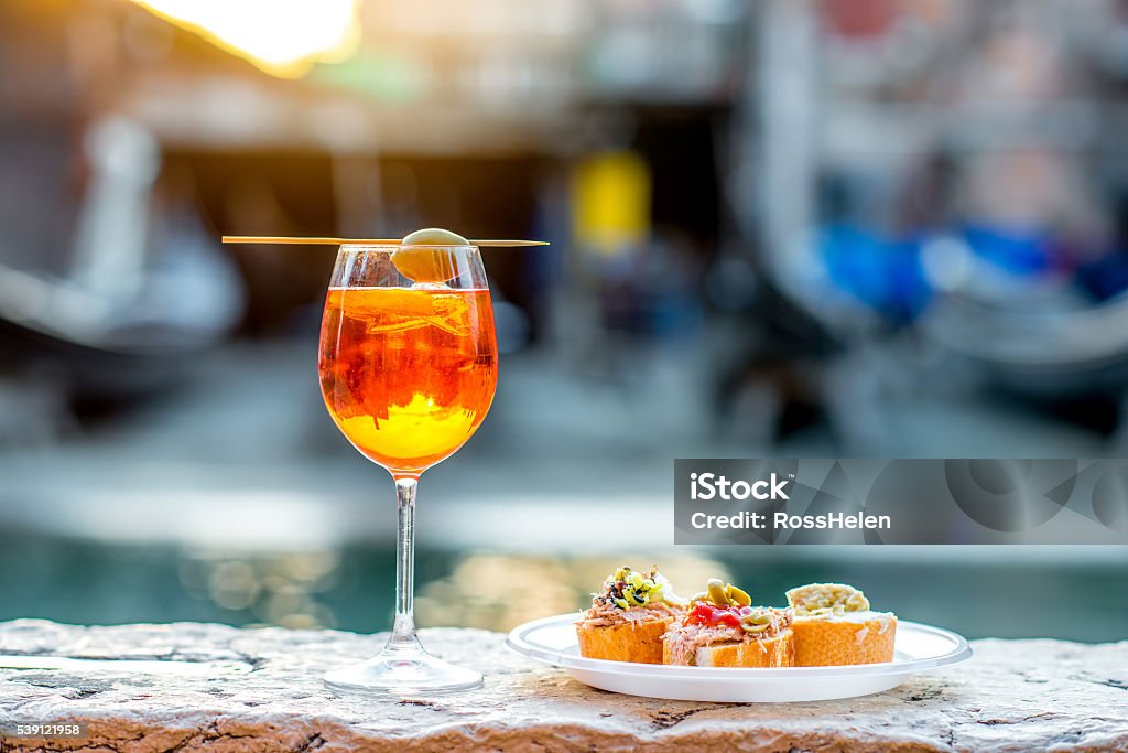 Spritz Aperol with cicchetti Spritz Aperol drink with venetian traditional snacks cicchetti on the water chanal background in Venice. Traditioanal italian aperitif. Image with small depth of field Aperitif Stock Photo