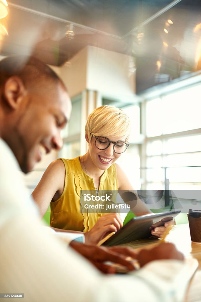 Dos milenaria creativa los propietarios de pequeñas de negocios trabajando con los medios sociales - Foto de stock de Oficina libre de derechos