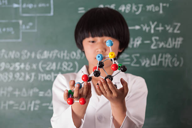 asian girl standing in front of chalk board with complicated formula and calculation studio shot