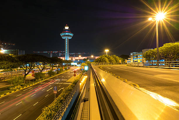 aeroporto changi de cingapura à noite com torre de controle de tráfego aéreo - factory night skyline sky - fotografias e filmes do acervo