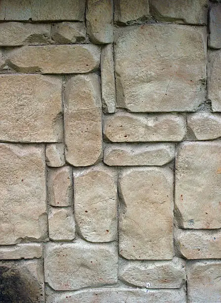 Light brown stones of varying sizes built into a wall, can be used as background