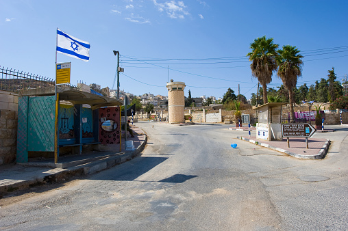 Hebron, Israel - 10 October, 2014: Deserted street with watchtower in the jewish quarter near the center of Hebron