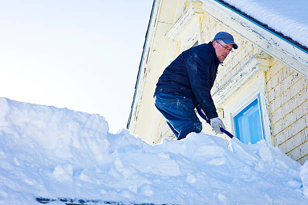 istock Senior Man Shovels Snow from a Roof Top. 539149761