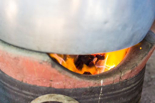 flame on charcoal in old traditional stove brazier for boiling water