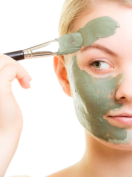 Skin care. Woman applying clay mud mask on face. Skin care. Woman applying with brush clay mud mask on face isolated. Girl taking care of dry complexion. Beauty treatment. green clay stock pictures, royalty-free photos & images