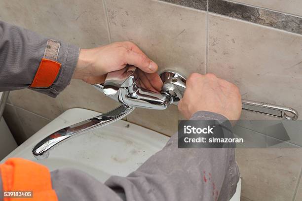 Plumber Fixing Faucet In A Bathroom Stock Photo - Download Image Now - 2015, Adjustable Wrench, Adult