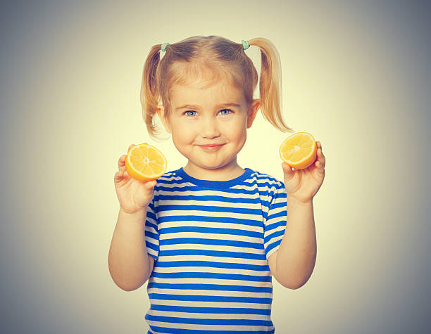 istock Little Funny girl keeps lemons 539199620