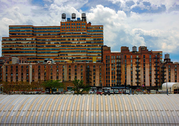 Starrett-Lehigh Building (lofts) with horizontal strip windows and red brick banded spandrels in the background, Central Stores or Terminal Warehouse Company building with vertical slot windows in the mid-ground, and the New York City Sanitation Department ribbed metal shed roof in West Chelsea.