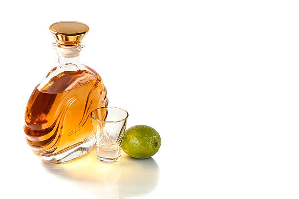 бутылка и бокал текила с ярко-желтый в белый фон - gin decanter whisky bottle стоковые фото и изображения