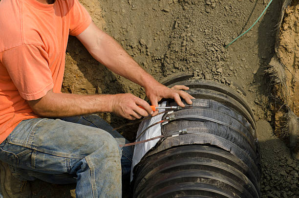 istock Excavation contractor installs plastic sewer drain pipe 539205195