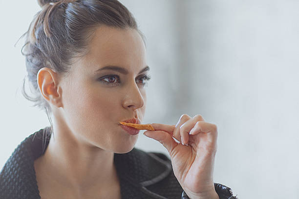 Beautiful young woman eating muesli bar snack stock photo