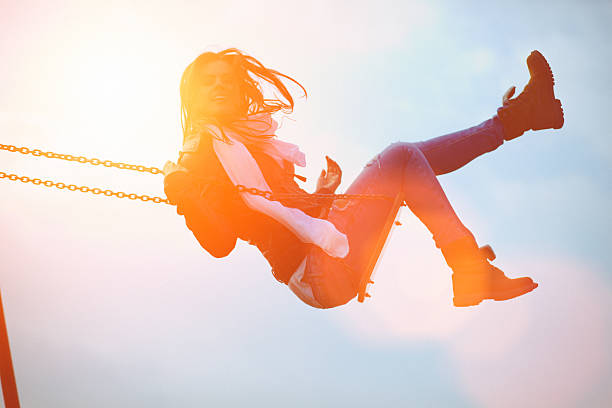istock Young woman having fun swinging in sunlight 539205597