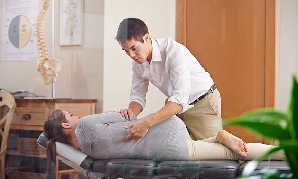 Adjust your health Shot of a chiropractor adjusting a young woman's spine osteopath photos stock pictures, royalty-free photos & images