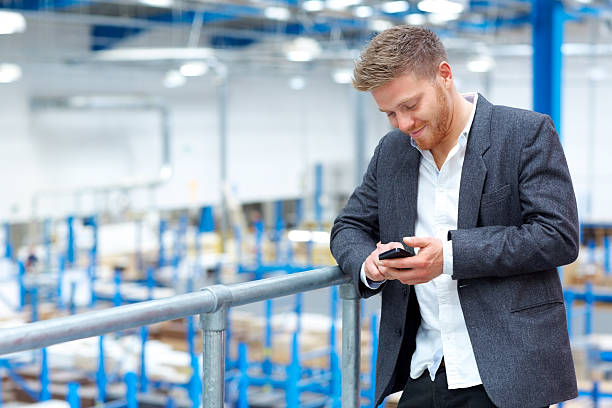 istock Young man in factory using mobile phone 539206439