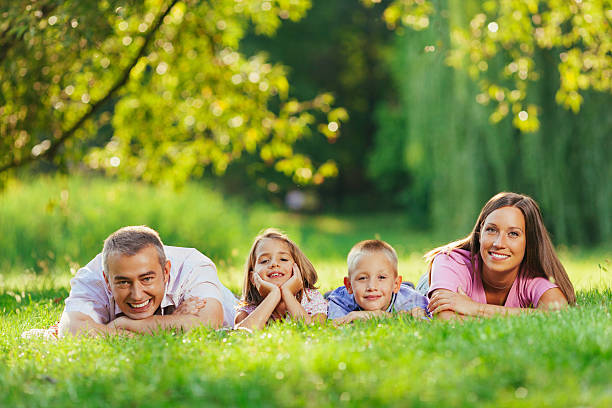istock Delightful family smiling at camera in the park 539206855