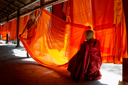 Two young monks hanging out robes to dry at the temple compound.