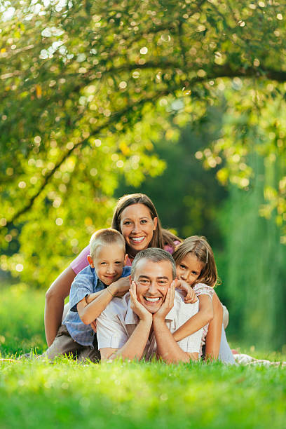 istock Delightful family smiling at camera in the park 539207115